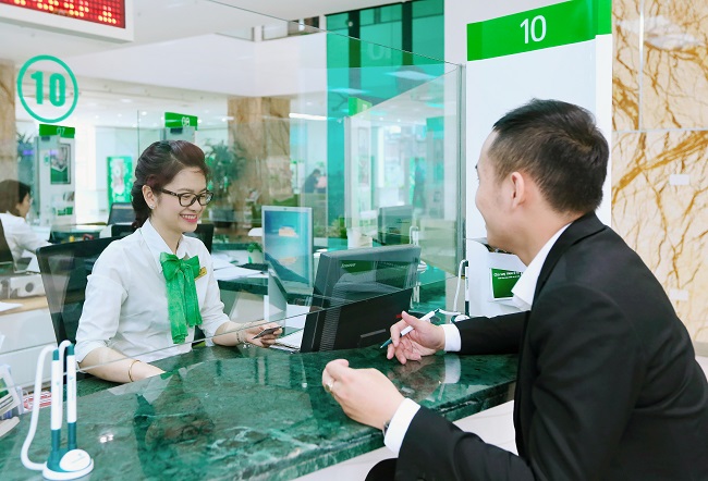 "Khách hàng giao dịch tại quầy giao dịch Vietcombank với nhân viên tận tình hỗ trợ - Dịch vụ ngân hàng uy tín, chuyên nghiệp tại Việt Nam". (Ảnh: ST)